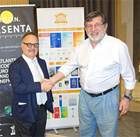 Stretta di mano allo stand, con il roll-up dell’editore alle spalle